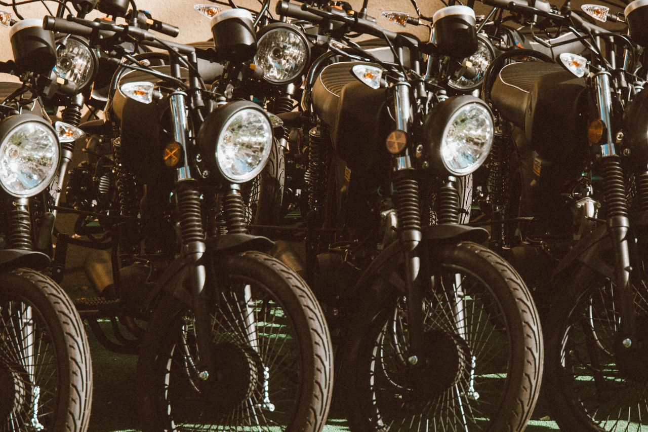 A stylish lineup of vintage motorcycles parked in a sunlit outdoor setting.